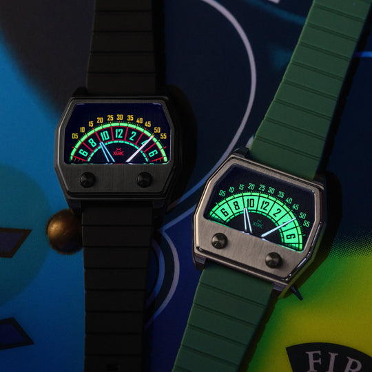 Two analog-style wristwatches with rectangular dark cases and strap designs, shown on a colorful graphic background. One watch has a black strap and black case, while the other has a green strap and green case.