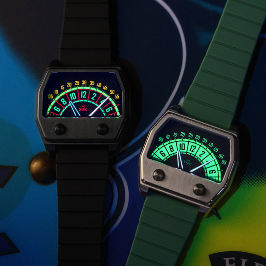Two analog-style wristwatches with rectangular dark cases and strap designs, shown on a colorful graphic background. One watch has a black strap and black case, while the other has a green strap and green case.