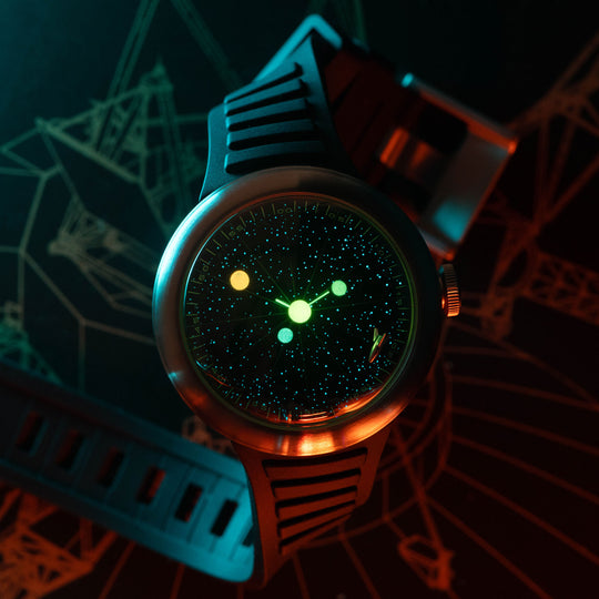 A wristwatch with a dark galaxy-style dial and a black textured strap, photographed in dramatic colored lighting against a dark background with faint geometric line art.